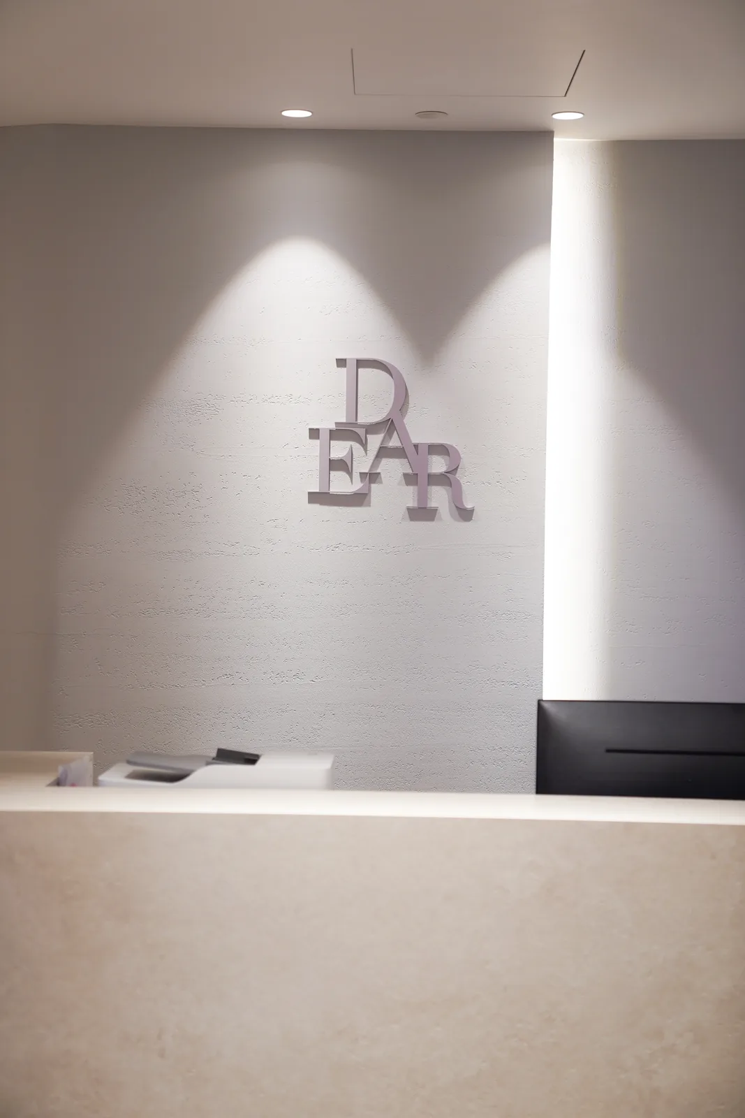 Mauve DEAR lettering above the Floor A reception counter at Dear Clinic Cheongdam
