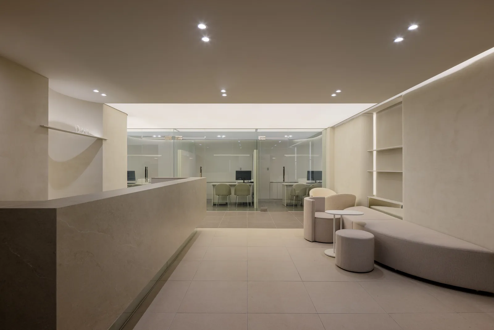 Main reception with stone counter and bouclé armchairs at Dear Clinic Cheongdam