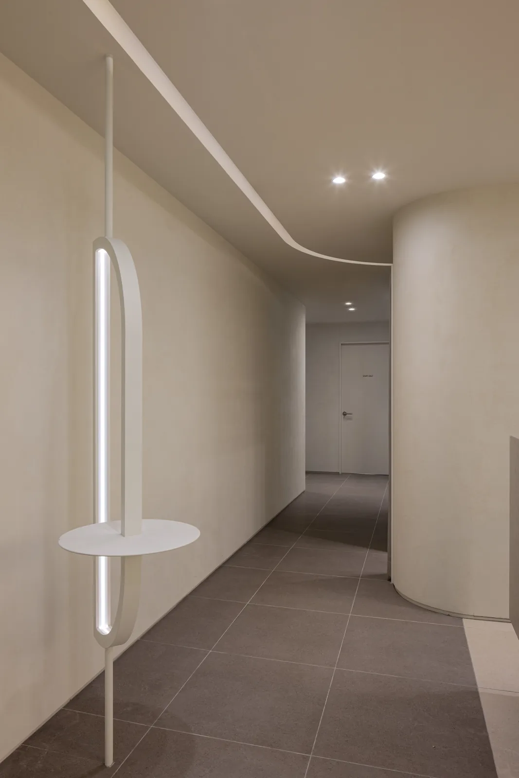 Ring-shaped wall light in a curved corridor at Dear Clinic Cheongdam