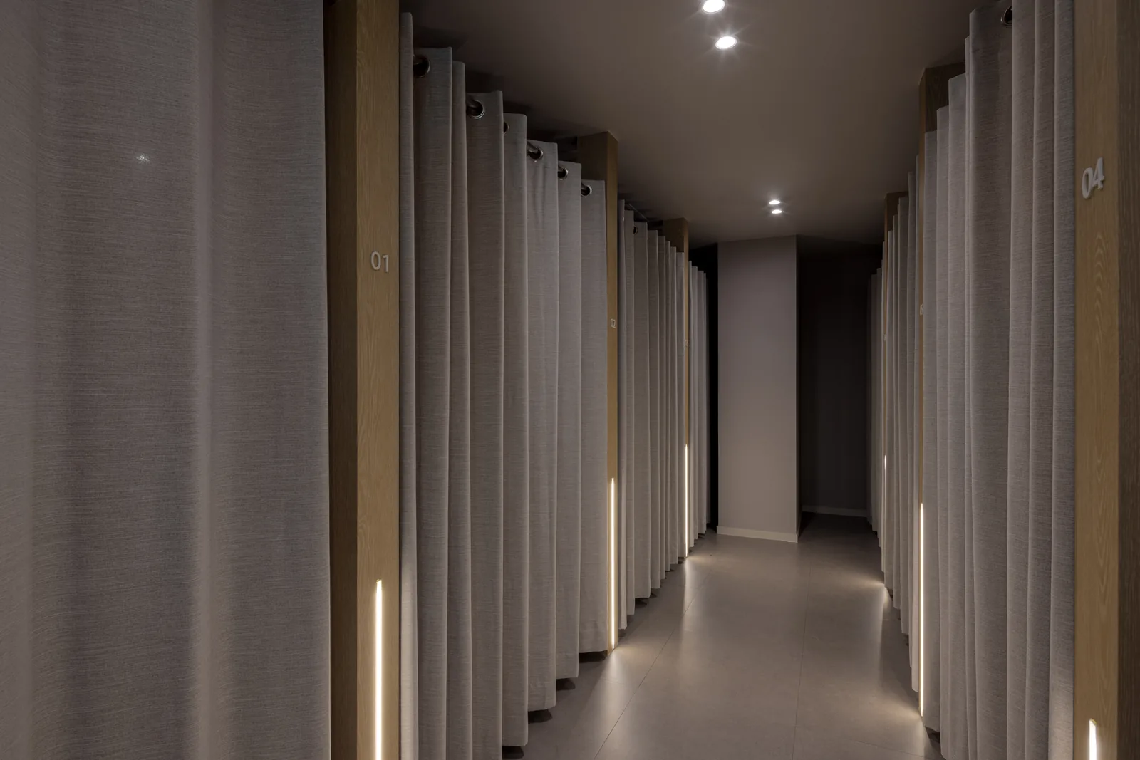 Private curtained treatment bays at Dear Clinic Cheongdam, each numbered and separately lit