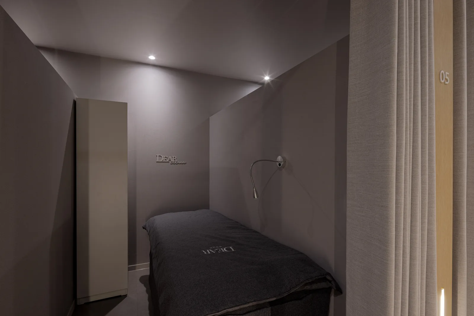 Private recovery bay at Dear Clinic with a DEAR-embroidered blanket and soft reading light