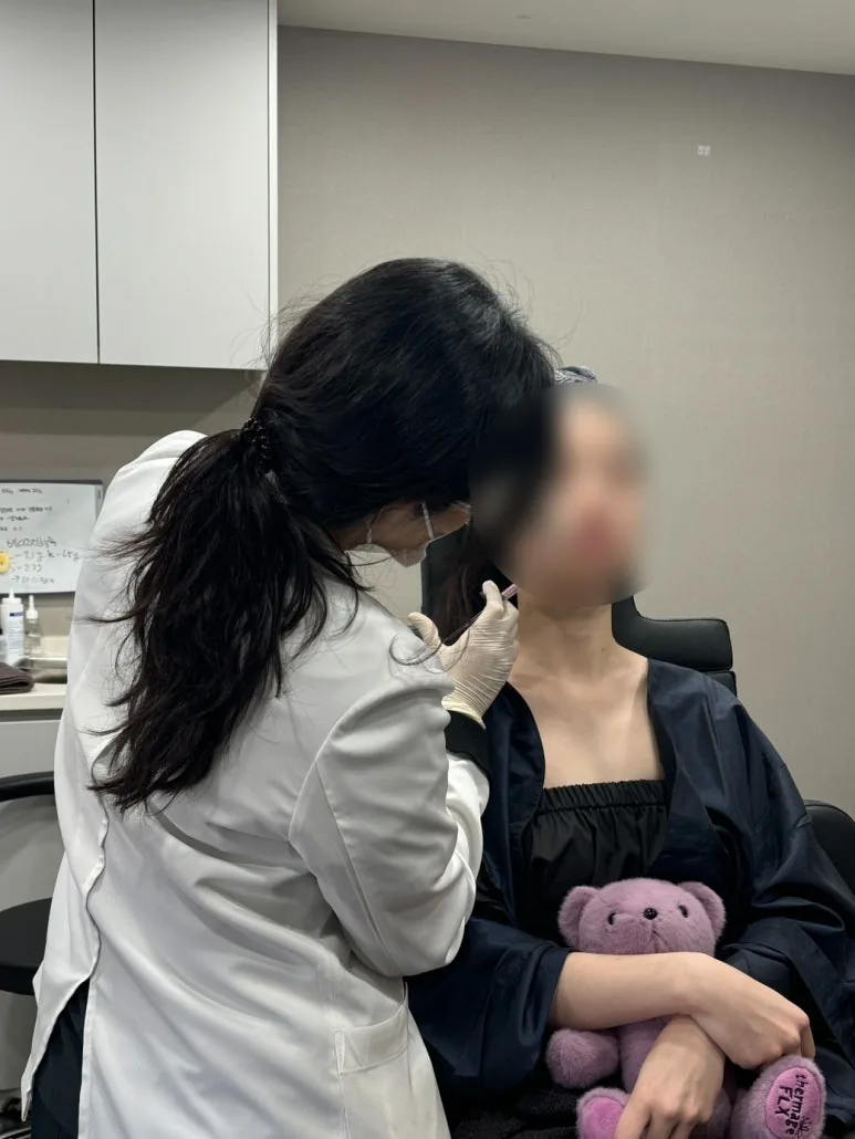 Doctor marking the pre-treatment grid on a patient's face before a Thermage FLX session at Dear Clinic