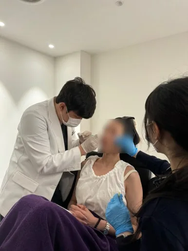 Doctor administering an injectable treatment along the jawline at Dear Clinic Cheongdam